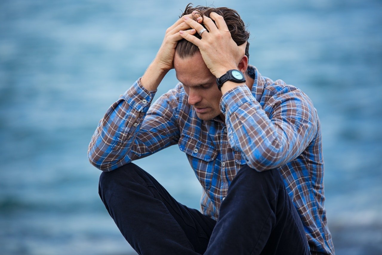 Depressed man sitting in front of river