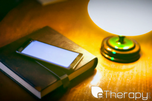 Vintage journal next to a glowing smartphone on an oak table - Is Journaling Old Fashioned or a Useful Tool