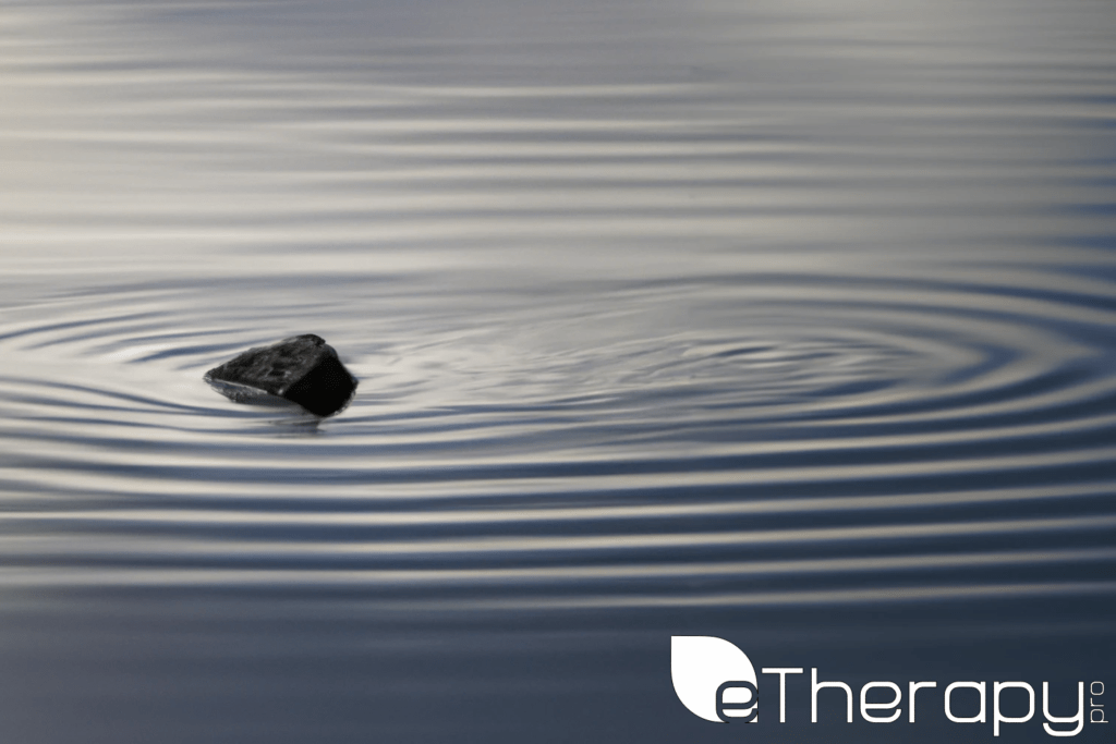 A serene lake with a single stone creating ripples - Overthinking Are We Fueling Our Own Anxiety Cycles