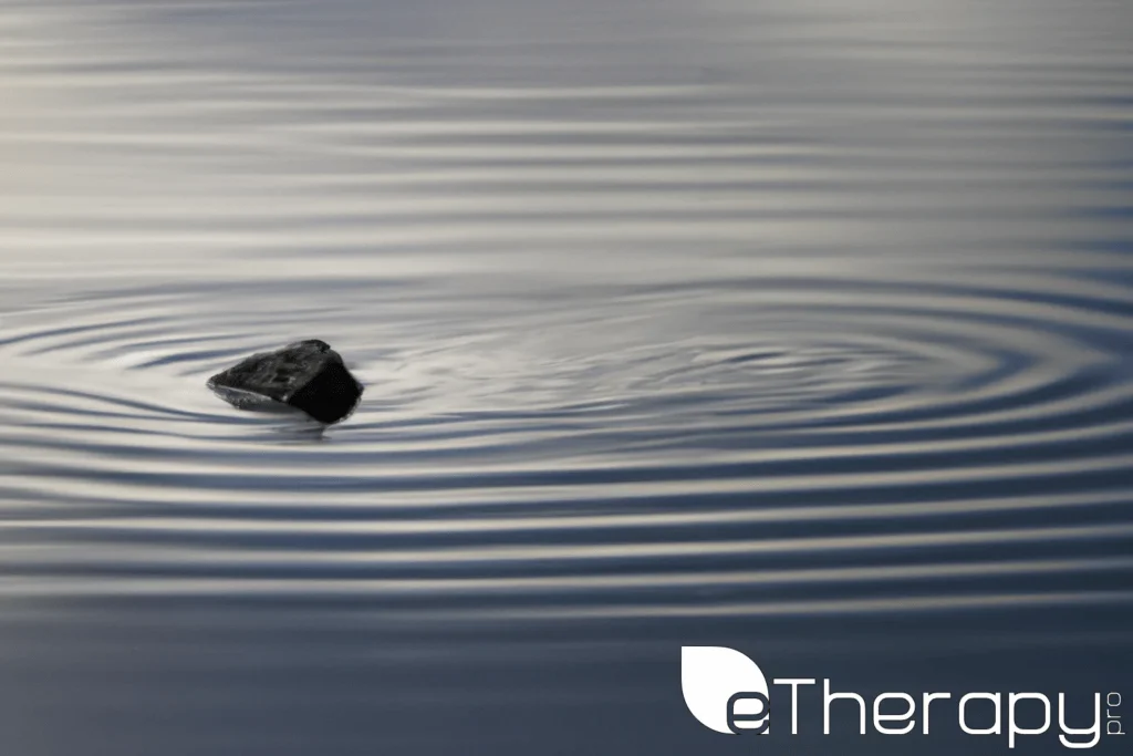 A serene lake with a single stone creating ripples - Overthinking Are We Fueling Our Own Anxiety Cycles