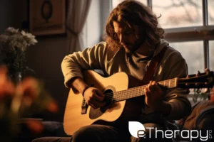 An individual around 30 playing an acoustic guitar in a cozy room - What Fuels Mental Health